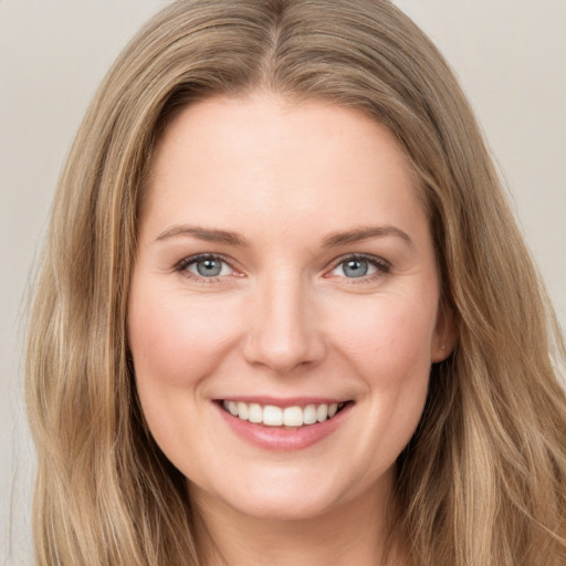 Joyful white young-adult female with long  brown hair and green eyes