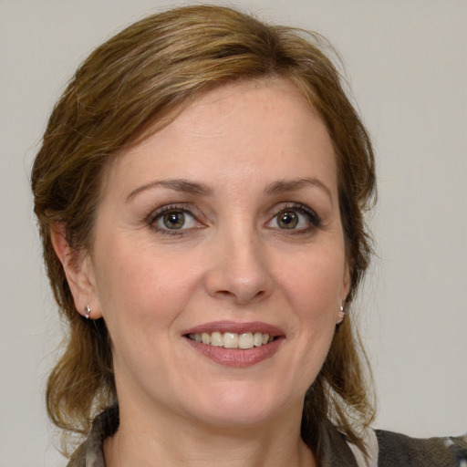 Joyful white adult female with medium  brown hair and grey eyes