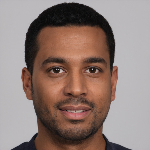 Joyful black young-adult male with short  black hair and brown eyes