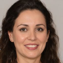 Joyful white adult female with long  brown hair and brown eyes