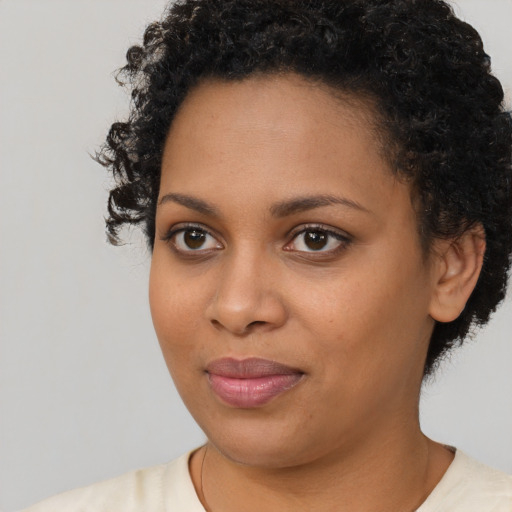 Joyful black young-adult female with short  brown hair and brown eyes