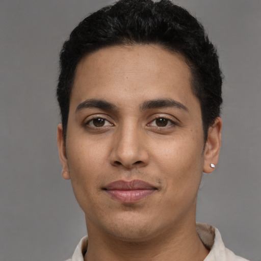 Joyful latino young-adult male with short  black hair and brown eyes