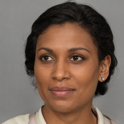 Joyful black young-adult female with medium  brown hair and brown eyes