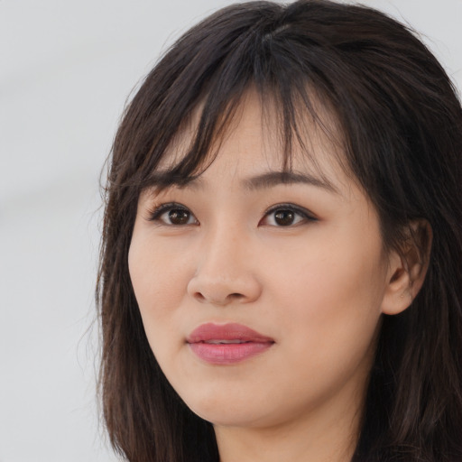 Joyful asian young-adult female with long  brown hair and brown eyes