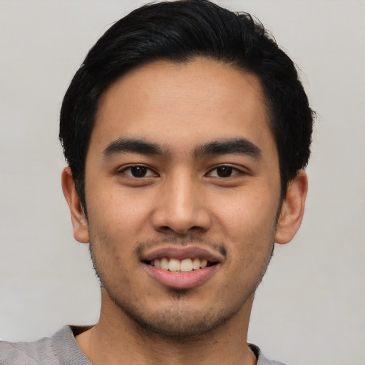 Joyful latino young-adult male with short  black hair and brown eyes