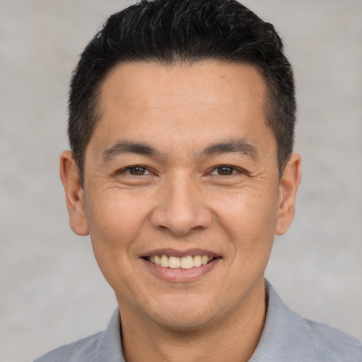Joyful white adult male with short  black hair and brown eyes