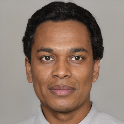 Joyful black young-adult male with short  black hair and brown eyes