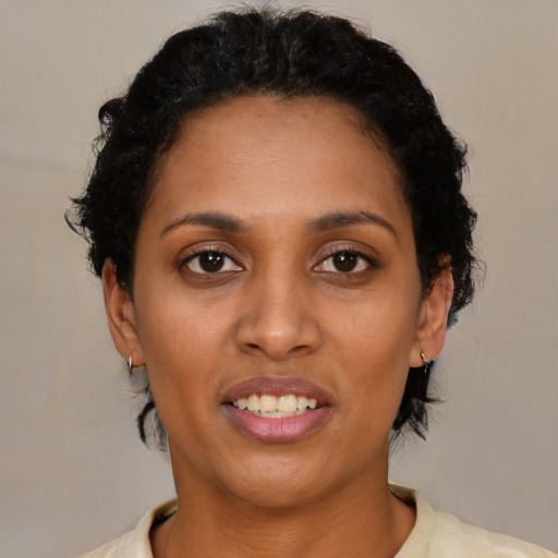 Joyful black young-adult female with short  brown hair and brown eyes