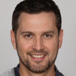 Joyful white adult male with short  brown hair and brown eyes