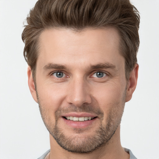 Joyful white young-adult male with short  brown hair and grey eyes