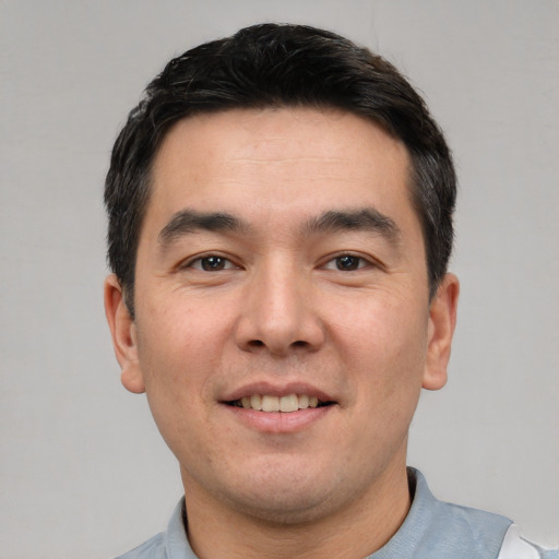 Joyful white young-adult male with short  black hair and brown eyes