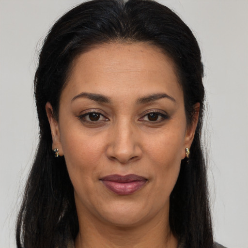 Joyful latino adult female with long  brown hair and brown eyes