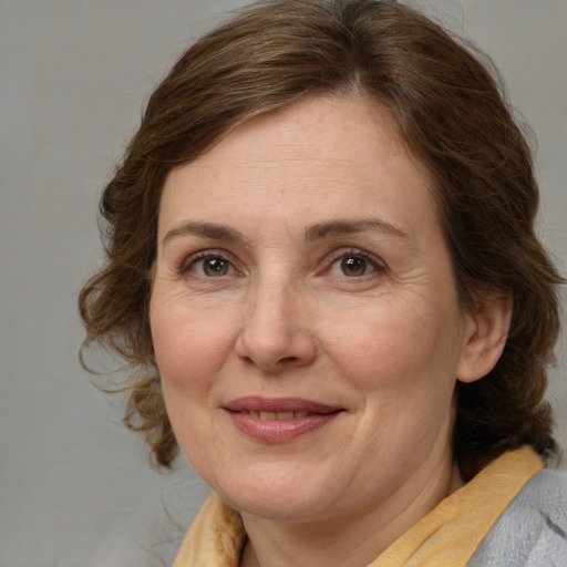 Joyful white adult female with medium  brown hair and blue eyes