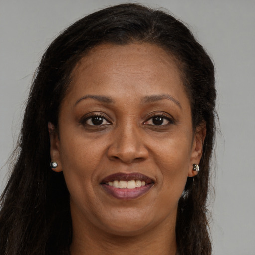 Joyful black adult female with long  brown hair and brown eyes