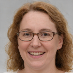 Joyful white adult female with medium  brown hair and blue eyes