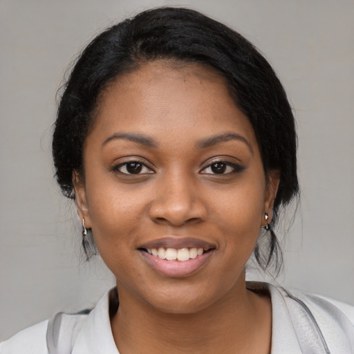 Joyful black young-adult female with medium  black hair and brown eyes