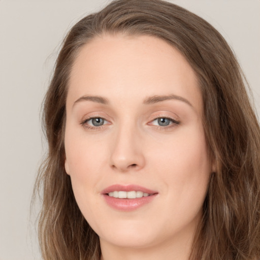 Joyful white young-adult female with long  brown hair and green eyes