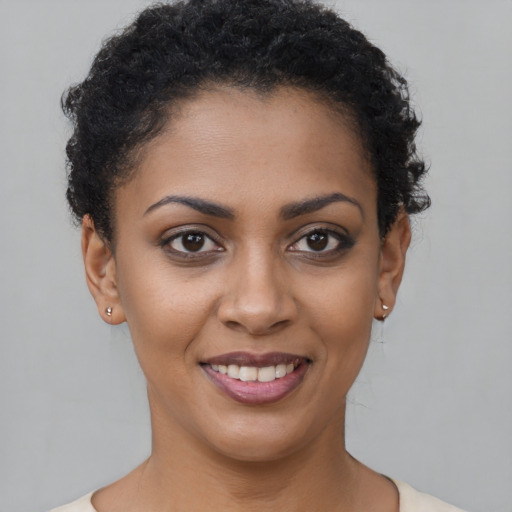 Joyful black young-adult female with short  brown hair and brown eyes