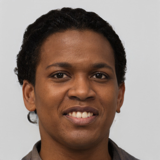 Joyful black young-adult female with short  black hair and brown eyes