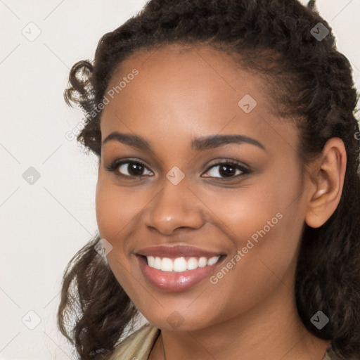 Joyful black young-adult female with long  brown hair and brown eyes