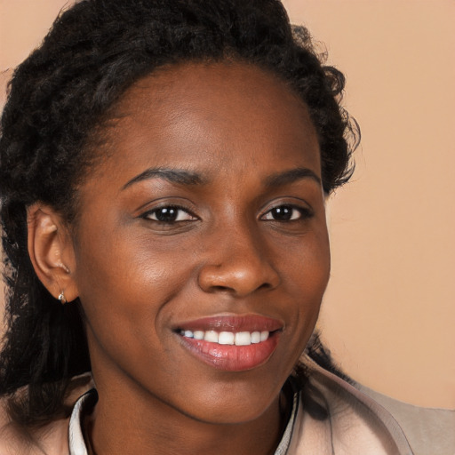 Joyful black young-adult female with long  brown hair and brown eyes