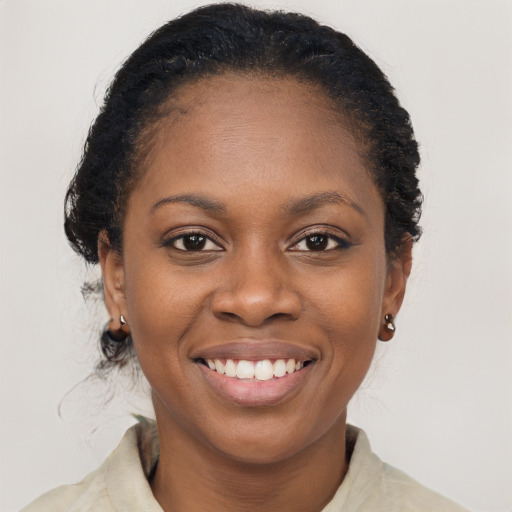 Joyful black young-adult female with medium  brown hair and brown eyes
