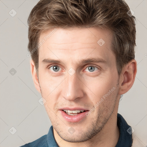 Joyful white young-adult male with short  brown hair and grey eyes