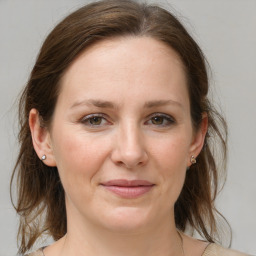 Joyful white adult female with medium  brown hair and grey eyes