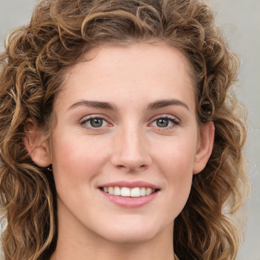 Joyful white young-adult female with long  brown hair and green eyes