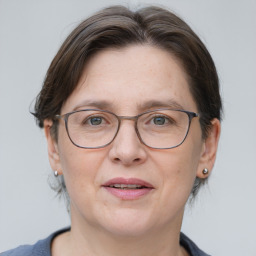 Joyful white adult female with medium  brown hair and grey eyes