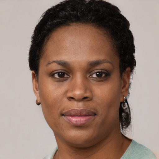 Joyful black young-adult female with short  black hair and brown eyes