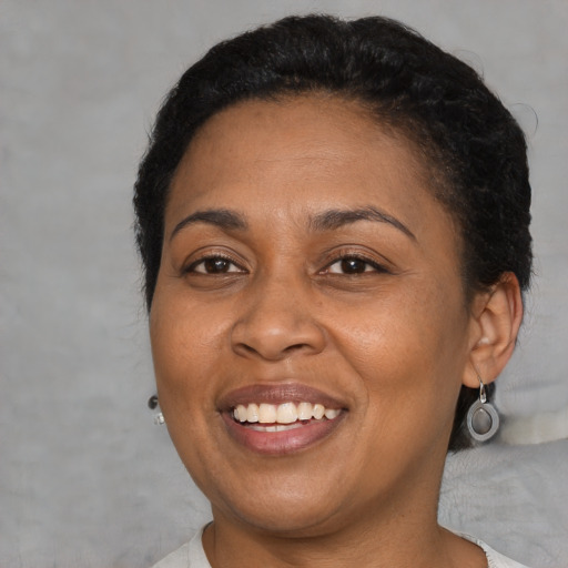 Joyful latino adult female with short  brown hair and brown eyes