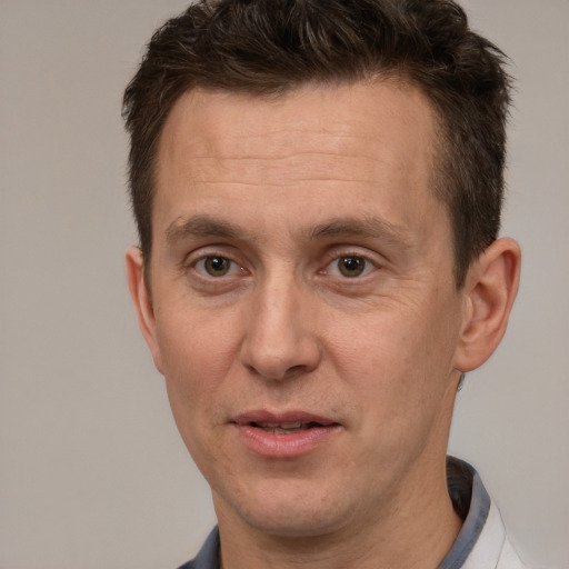 Joyful white adult male with short  brown hair and brown eyes