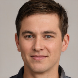 Joyful white young-adult male with short  brown hair and grey eyes