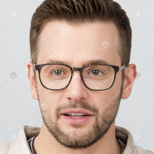 Joyful white young-adult male with short  brown hair and grey eyes