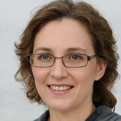 Joyful white adult female with medium  brown hair and blue eyes