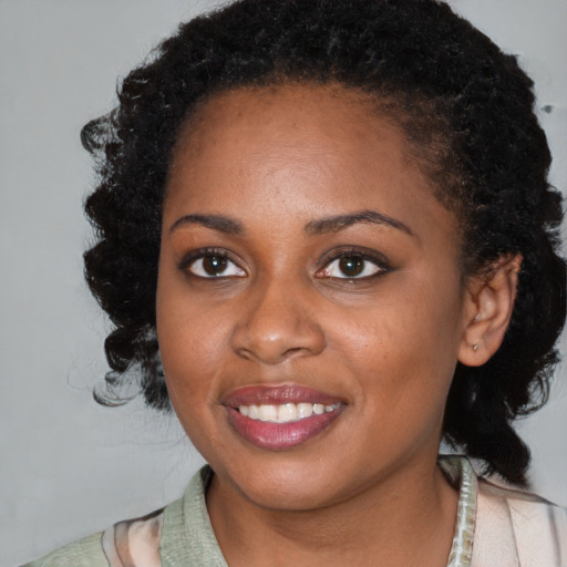 Joyful black young-adult female with medium  brown hair and brown eyes