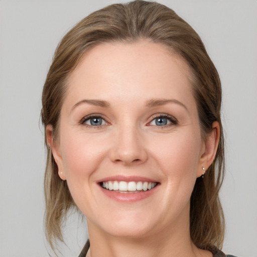 Joyful white young-adult female with medium  brown hair and grey eyes