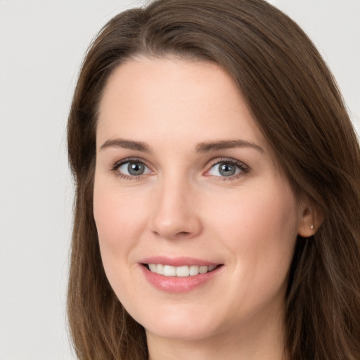 Joyful white young-adult female with long  brown hair and grey eyes