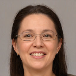 Joyful white adult female with long  brown hair and brown eyes