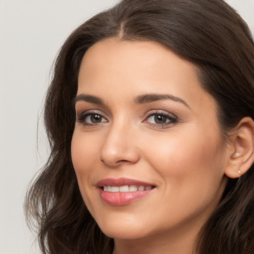 Joyful white young-adult female with long  brown hair and brown eyes