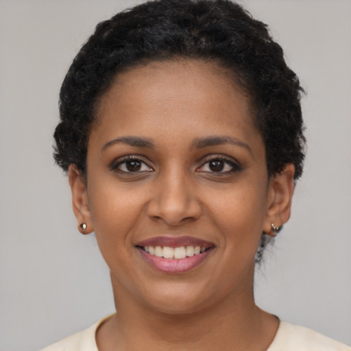 Joyful black young-adult female with short  brown hair and brown eyes