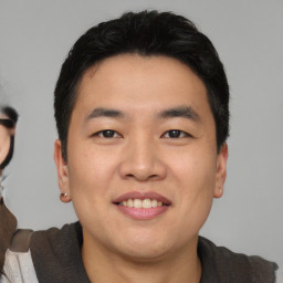 Joyful asian young-adult male with short  black hair and brown eyes