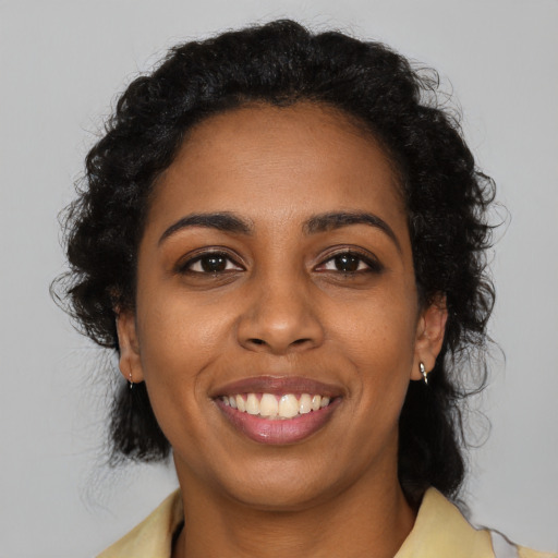 Joyful black young-adult female with medium  black hair and brown eyes