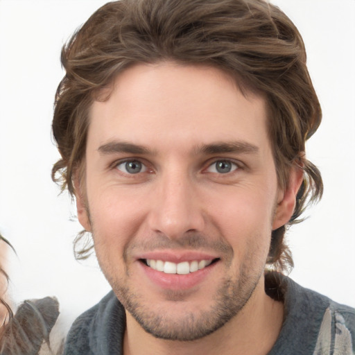 Joyful white young-adult male with medium  brown hair and grey eyes