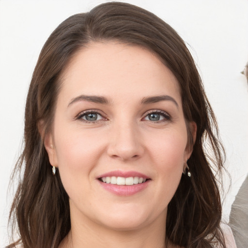 Joyful white young-adult female with long  brown hair and grey eyes