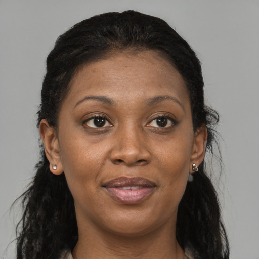 Joyful black adult female with long  brown hair and brown eyes