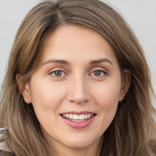 Joyful white young-adult female with long  brown hair and brown eyes