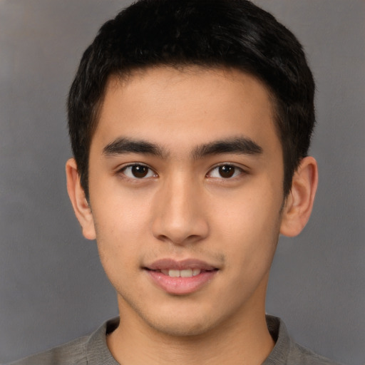 Joyful asian young-adult male with short  brown hair and brown eyes