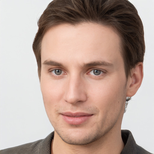 Joyful white young-adult male with short  brown hair and grey eyes